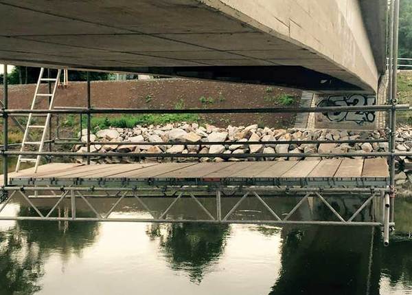 Arbeitsgerüst unter Brücke über Fluss für Bauarbeiten und Brückensanierung montiert.